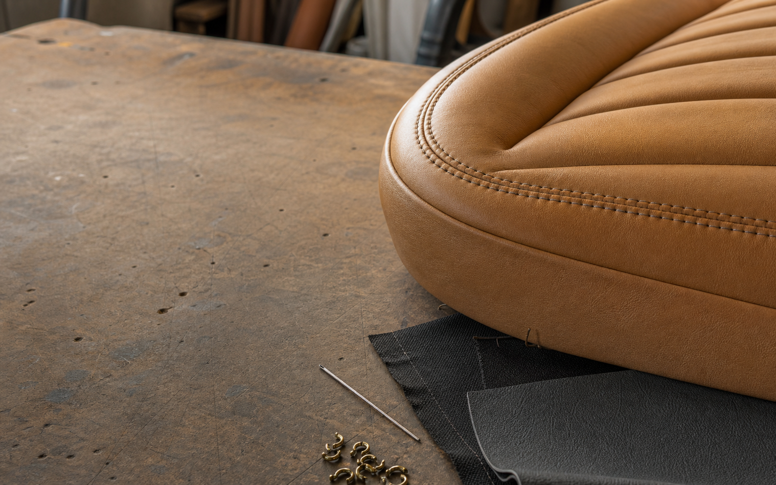 Stitched leather, canvas, and vinyl upholstery materials on a workbench